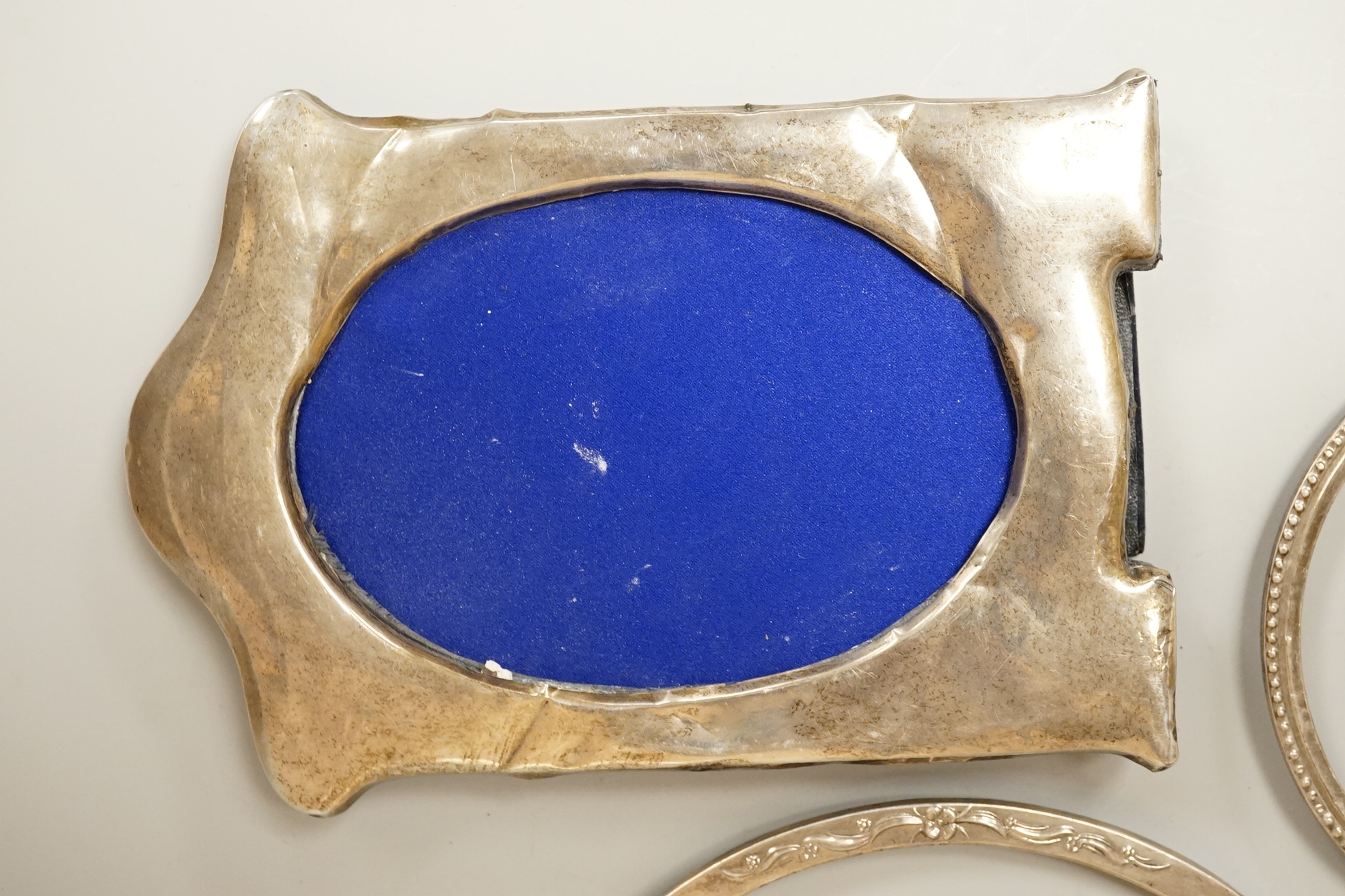 Four assorted early 20th century silver mounted photograph frames, the largest by Sanders & Mackenzie, Birmingham, 1915, 30.3cm by 21.6cm, together with two small Spanish white metal mounted photograph frames.
